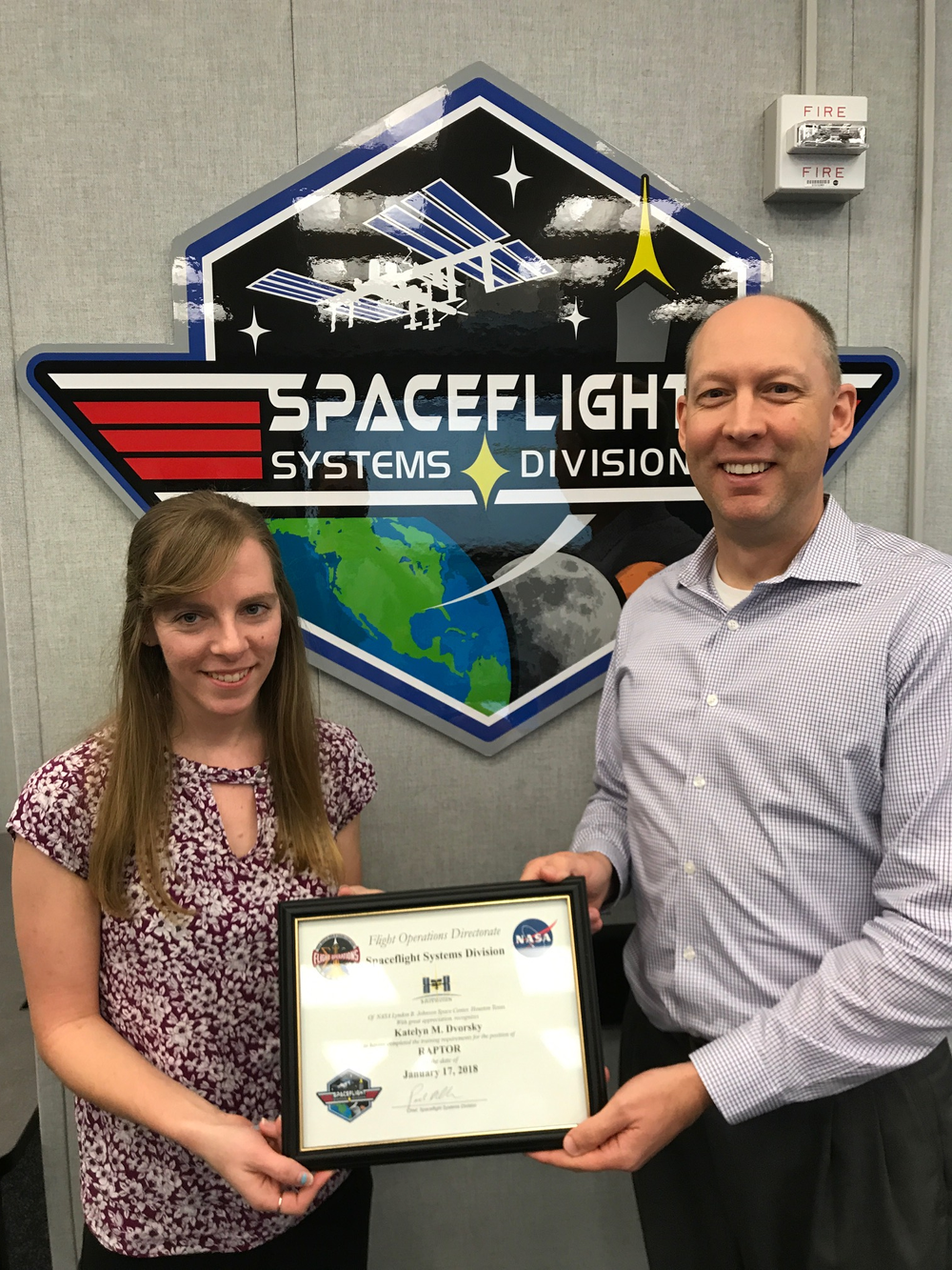 A young woman receives a framed certificate as an award.